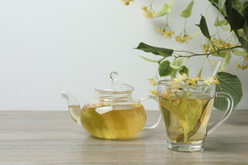 cup of herbal tea with linden flowers on wooden background