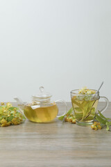 cup of herbal tea with linden flowers on wooden background