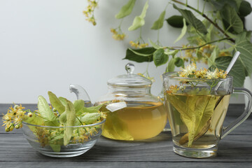 cup of herbal tea with linden flowers on wooden background