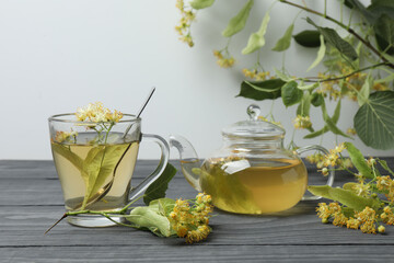 cup of herbal tea with linden flowers on wooden background