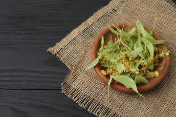 cup of herbal tea with linden flowers on wooden background