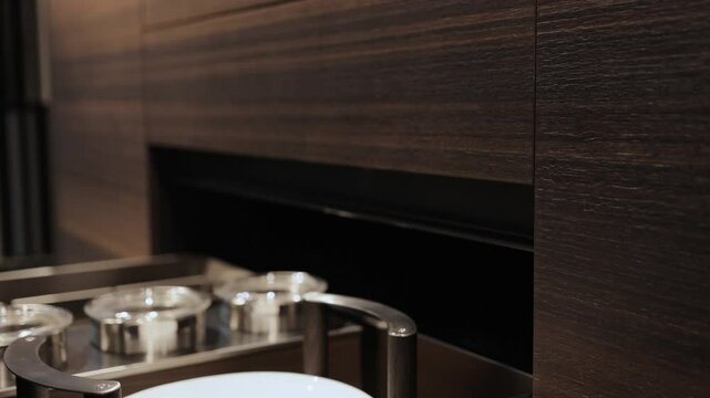 Close-up of a woman's hand opening an empty kitchen drawer. Stylish kitchen with marble countertops. Experience an elegantly designed modern drawer mechanism that aligns with your hands movement.