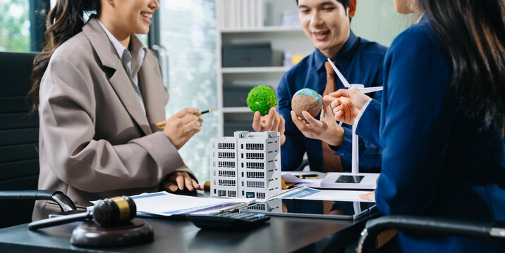 Professional team discusses clean energy and real estate contracts with wind turbines, eco globe, and gavel for sustainability, law
