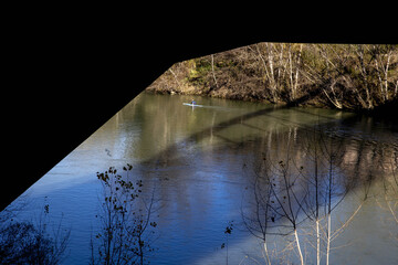 Rower under bridge on the Tiber river, Rome, Italy