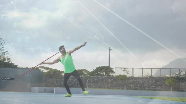 Athlete planting foot on blue track twisting hips hurling javelin with digital overlay for practice