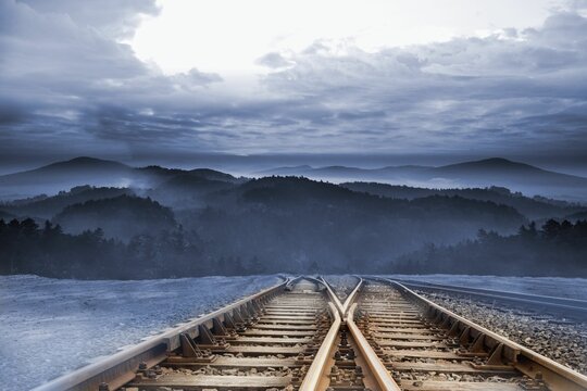 Fototapeta Train tracks leading to misty mountains