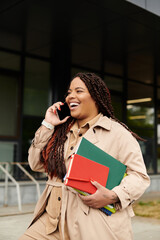 University teacher joyfully chatting on phone while carrying books outside campus building