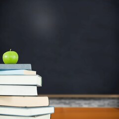 Green apple on pile of books in classroom