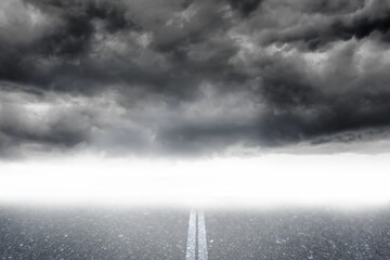 Flat design showing empty asphalt road with faded center line leading into fog under storm clouds