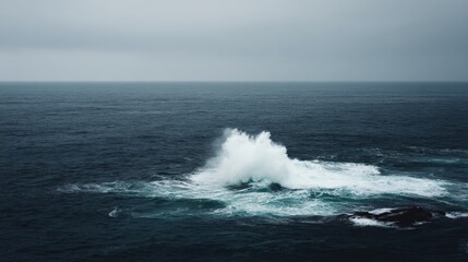 Dramatic telephoto shot of a powerful crashing ocean wave with white spray and deep blue hues under overcast skies for an intense seascape with negative space on the right