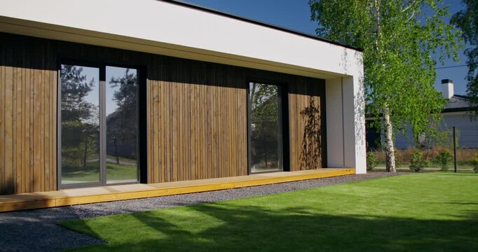 The facade of the house with panoramic windows, close-up. A sunny summer day, no people