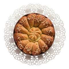 Golden-brown flower-shaped bread with sesame seeds, presented on an ornate white lace doily, viewed from above.