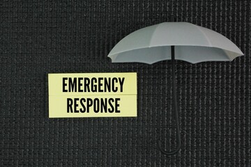 Umbrella and paper with the word Emergency response. the immediate actions taken to manage, control, or mitigate the effects of an unexpected