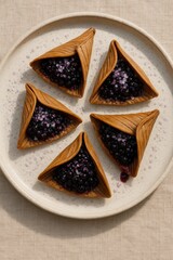 Bark-Folded Pastries with Wild Berry Filling Arranged on White Plate for Serving

