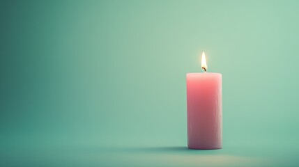 A single soft pink candle against a pastel green backdrop.