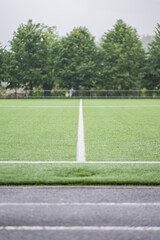 Vibrant green sports field awaits passionate players under cloudy skies
