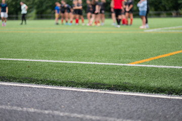 Team members gather for strategy discussion on a vibrant sports field