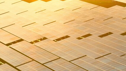 Expansive aerial shot of photovoltaic panels glowing in sunlight, representing the shift toward...