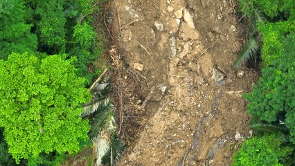 Bird's eye drone shot capturing a landslide triggered by intense rainfall, exposing bare soil and...