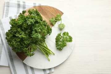 Fresh parsley on light wooden table, top view. Space for text