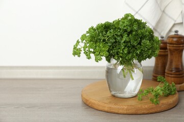 Fresh parsley in jar on table indoors. Space for text