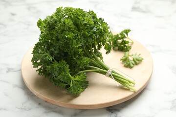 Bunch of fresh parsley on white marble table, closeup