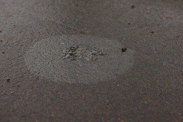 Stain of motor oil on asphalt, closeup view