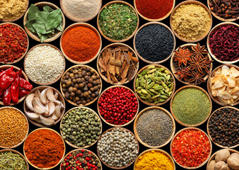 Set of different aromatic spices in bowls on black background, flat lay