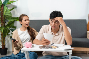 Financial Planning. Couple arguing over bills and budgeting while using smartphone.