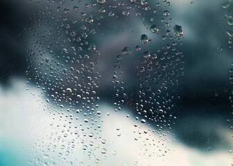 Rain droplets create a hazy view through the window on a cloudy day in a quiet urban setting