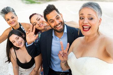 Bride and friends gesturing while taking a selfie at wedding reception