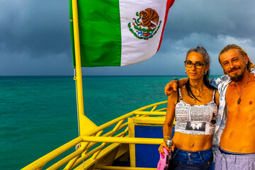 Couple traveling on ferry with mexican flag in Mexico.