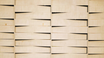 Modern wall with uneven geometric shapes in warm beige color, creating abstract architectural...