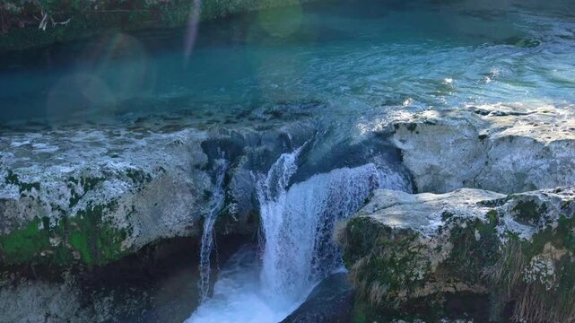 Panning shot from the forest down the river into multiple waterfalls