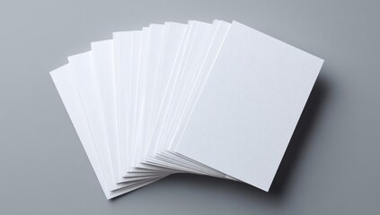 A fanned stack of blank, rectangular, white cards on a gray background, showcasing clean, minimalist design
