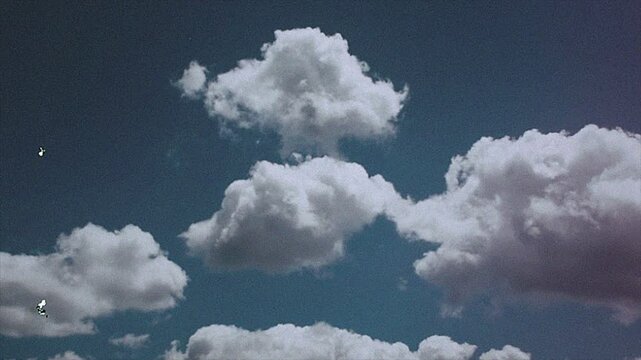 Peaceful Blue Sky with White Clouds Film Grain and Scratches Creating a Vintage Aesthetic Copy Space