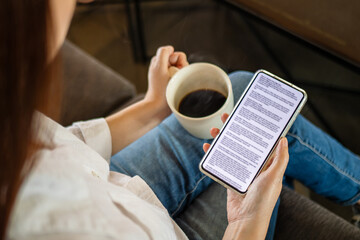 woman hand holding coffee cup and phone, reading text on mobile screen for digital press article...