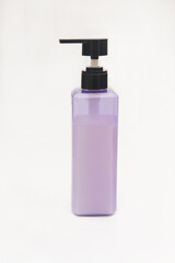 Purple shampoo bottle with black pump on a white background.