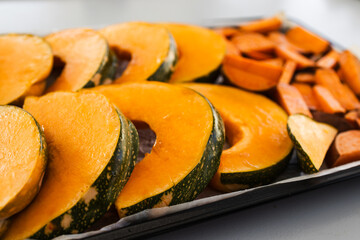 oven tray with kent pumpkin slices and sweet potato chips ready to roast