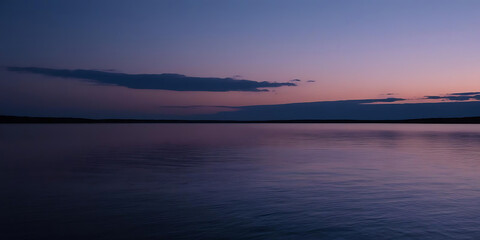 Fototapeta premium Twilight Sky with Purple and Blue Reflections on Calm Water and Soft Clouds on the Horizon