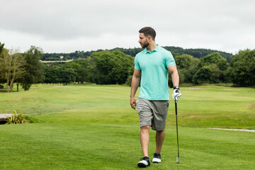 Man wearing golf attire walking across fairway with club, glove and shoes, copy space