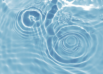 Abstract blurred shades of blue water background. Light and shadow ripples or splashes surface of water texture. Water waves and bubbles with shining and reflection pattern photography for​ artwork.