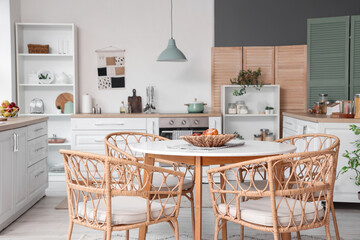 Interior of kitchen with dining table, counters and houseplants