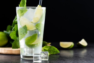 Classic Mojito Cocktail with Lime and Mint on black slate background. Copy space