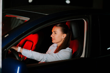 Young woman driving a car with ambient lighting in a nighttime setting
