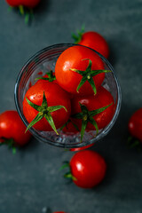 Cherry tomatoes in a beautiful glass bowl on a dark background isolated close-up