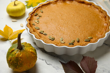 Baking dish with tasty pumpkin pie on white marble background