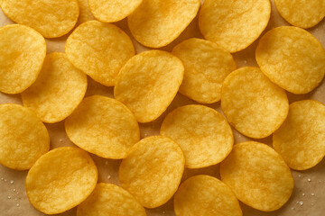 Obraz premium Crispy Golden Potato Chips Flat Lay on Brown Paper Background Snack Food