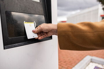 Businesswoman paying with contactless credit card at charging station
