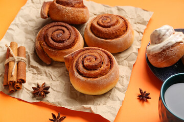 Tasty cinnamon rolls on orange background